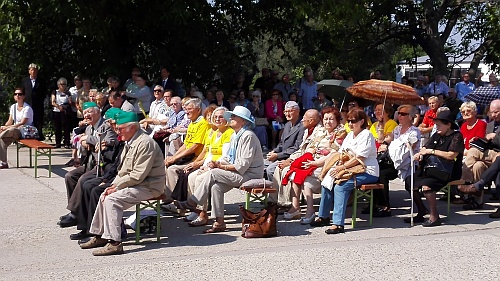 Účastníci pietnej spomienky pre bránou väznice.